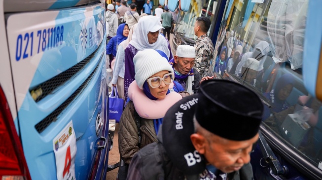 Jamaah haji berjalan menuju bus tujuan Depok di UPT Asrama Haji Embarkasi Bekasi, Rabu (18/6/2025). Sebanyak 442 jamaah haji kloter 12 JKS tiba di Asrama Haji Embarkasi Bekasi setelah penerbangannya sempat terganggu karena pesawat Saudia Airlines SV 5276 rute JeddahâJakarta yang mereka tumpangi mendapat ancaman bom sehingga terpaksa mendarat di Bandara Kualanamu, Medan, Sumatra Utara. [Antara/I Gede Ferlian Septa Wahyusa]