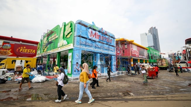 Pekerja menyelesaikan pembuatan gerai yang akan berpartisipasi dalam Jakarta Fair 2025 di JIExpo, Kemayoran, Jakarta, Rabu (18/6/2025). [Suara.com/Alfian Winanto]