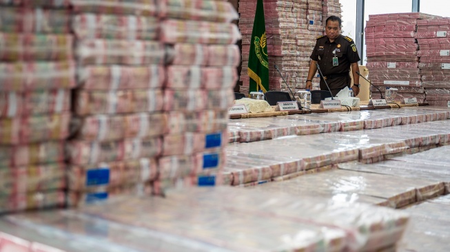 Petugas merapikan barang bukti uang sitaan saat konferensi pers kasus korupsi ekspor crude palm oil (CPO) di Gedung Bundar Jampidus Kejaksaaan Agung (Kejagung), Jakarta, Selasa (17/6/2025). [ANTARA FOTO/Bayu Pratama S/bar]