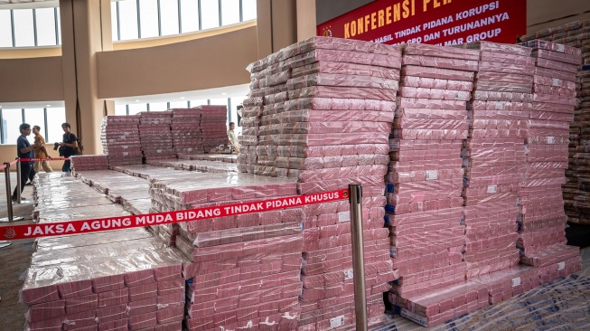 Petugas berjalan didekat barang bukti uang sitaan saat konferensi pers kasus korupsi ekspor crude palm oil (CPO) di Gedung Bundar Jampidus Kejaksaaan Agung (Kejagung), Jakarta, Selasa (17/6/2025). [ANTARA FOTO/Bayu Pratama S/bar]
