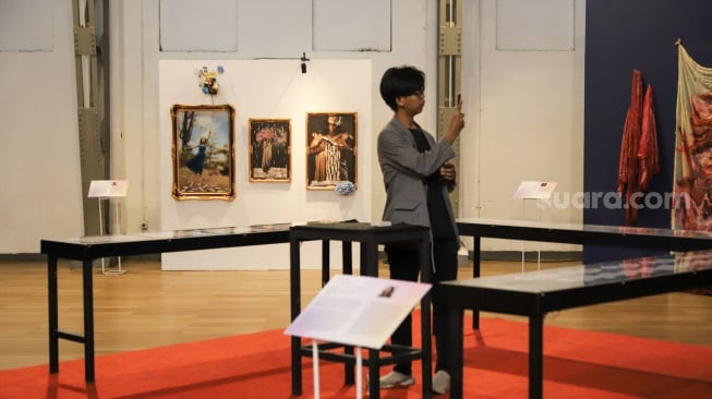 Pengunjung melihat karya seni dalam Pameran Jakarta Provoke 2025 di Gedung Pos Bloc, Jakarta, Kamis (19/6/2025). [Suara.com/Alfian Winanto]
