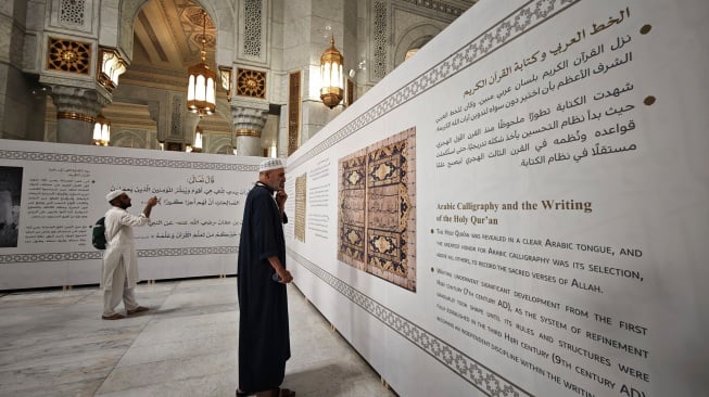 Pengunjung mengamati instalasi informasi pameran sejarah mushaf Al Quran di area perluasan ketiga Masjidil Haram di Makkah, Arab Saudi, Minggu (15/6/2025). [ANTARA FOTO/Andika Wahyu/tom]