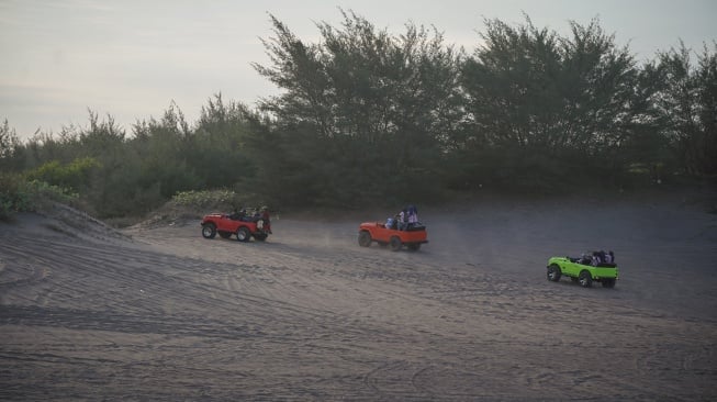 Pengunjung menaiki mobil jip wisata di kawasan Gumuk Pasir, Bantul, DI Yogyakarta, Kamis (19/6/2025). [ANTARA FOTO/Hendra Nurdiyansyah/nym]