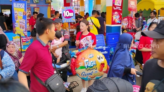 Potret pengunjung Jakarta Fair 2025 gendong tas snack jumbo, Minggu, 22 Juni 2025. [Suara.com/Adiyoga Priyambodo]