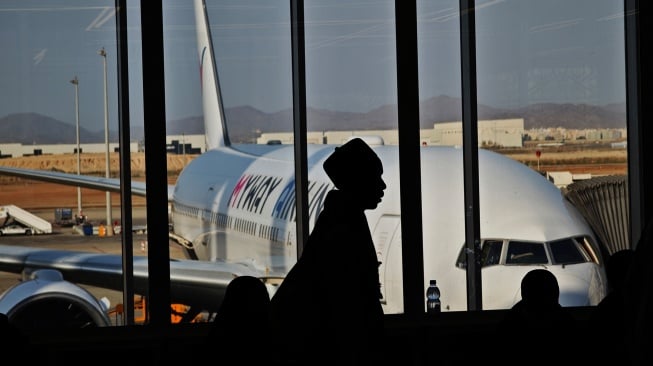Seorang haji asal Nigeria antre memasuki pesawat di King Abdulaziz International Airport, Jeddah, Arab Saudi, Senin (23/6/2025). [ANTARA FOTO/Andika Wahyu/tom]