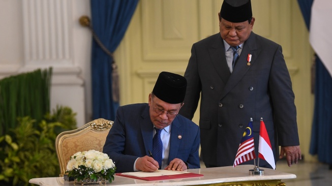 Presiden Prabowo Subianto (kanan) mendampingi Perdana Menteri Malaysia Anwar Ibrahim (kiri) mengisi buku tamu setibanya di Istana Merdeka, Jakarta, Jumat (27/6/2025). [ANTARA FOTO/Galih Pradipta/app/nym]