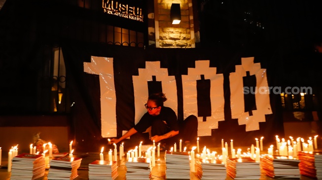 Peserta aksi membakar lilin saat peringatan 1.000 hari Tragedi Kanjuruhan di depan Museum Polri, Jakarta, Jumat (27/6/2025). [Suara.com/Alfian Winanto]