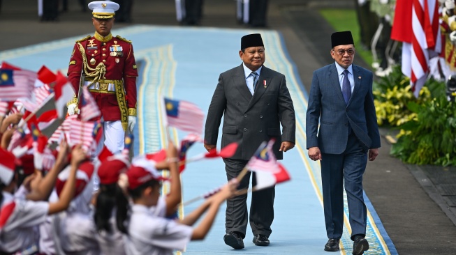 Presiden Prabowo Subianto (tengah) berjalan bersama Perdana Menteri Malaysia Anwar Ibrahim (kanan) saat menginspeksi pasukan dalam upacara kenegaraan di Istana Merdeka, Jakarta, Jumat (27/6/2025). [ANTARA FOTO/Hafidz Mubarak A/app/nym.]