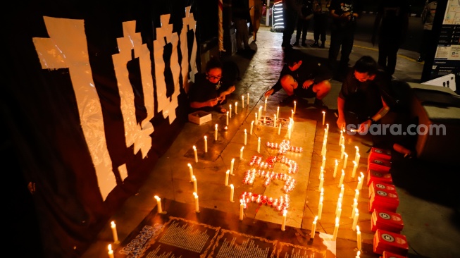 Peserta aksi membakar lilin saat peringatan 1.000 hari Tragedi Kanjuruhan di depan Museum Polri, Jakarta, Jumat (27/6/2025). [Suara.com/Alfian Winanto]