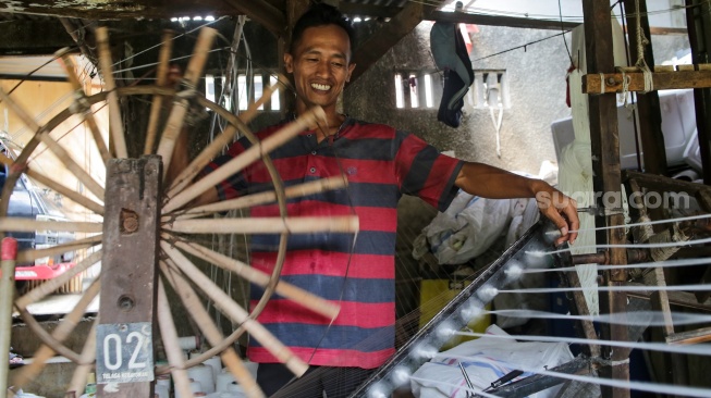 Pekerja memintal benang di sebuah industri kawasan Cipulir, Jakarta, Senin (30/6/2025). [Suara.com/Alfian Winanto]