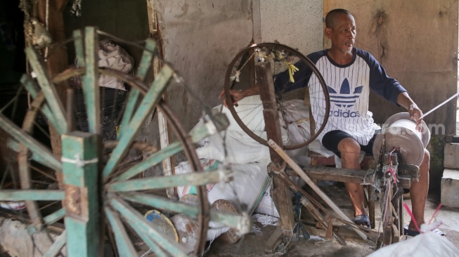 Pekerja memintal benang di sebuah industri kawasan Cipulir, Jakarta, Senin (30/6/2025). [Suara.com/Alfian Winanto]