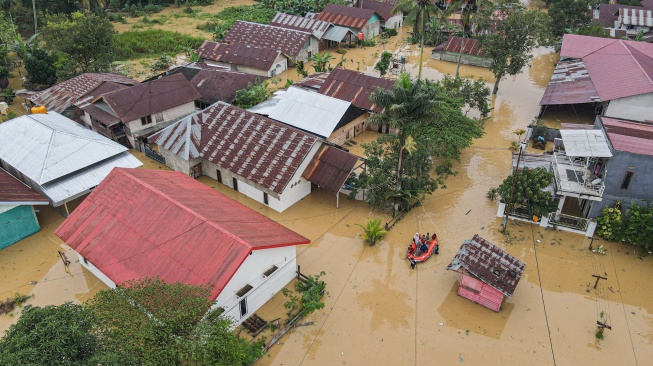 Foto udara petugas menggunakan perahu karet mengevakuasi warga terdampak banjir di Kelurahan Lepo-lepo, Kendari, Sulawesi Tenggara, Minggu (29/6/2025). [ANTARA FOTO/Andry Denisah/rwa]