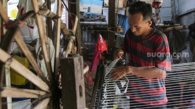 Pekerja memintal benang di sebuah industri kawasan Cipulir, Jakarta, Senin (30/6/2025). [Suara.com/Alfian Winanto]