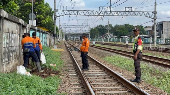 Petugas menutup tembok yang di sekitar kawasan Stasiun Jatinegara, Jakarta Timur yang digunakan sebagai tempat eseok-esek. (Suara.com/M. Yasir)