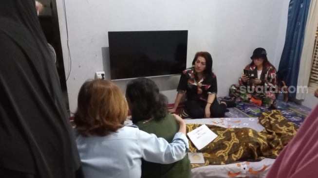 Istri dan anak Hamdan ATT, Hasibah dan Aisyah Kamaliah menangis di depan jenazah Hamdan ATT di rumah duka di kawasan Kramat Jati, Jakarta Timur pada Selasa, 1 Juli 2025.