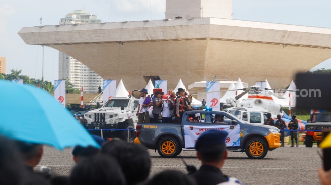 Warga menghadiri HUT ke-79 Bhayangkara di kawasan Monumen Nasional (Monas), Jakarta, Selasa (1/7/2025).  [Suara.com/Alfian Winanto]