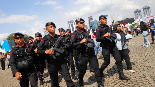 Warga menghadiri HUT ke-79 Bhayangkara di kawasan Monumen Nasional (Monas), Jakarta, Selasa (1/7/2025).  [Suara.com/Alfian Winanto]