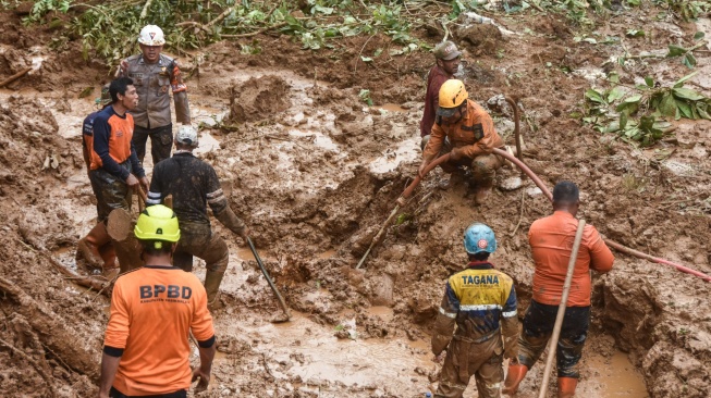 Tim SAR dibantu relawan dan warga membersihkan material tanah longsor saat pencarian korban yang tertimbun tanah longsor di Desa Tenjowaringin, Kecamatan Salawu, Kabupaten Tasikmalaya, Jawa Barat, Selasa (1/7/2025). [ANTARA FOTO/Adeng Bustomi/foc]