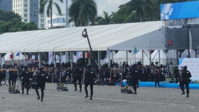 Parade robotik milik Polri dalam perayaan Hari Ulang Tahun (HUT) ke-79 Bhayangkara di Kawasan Monumen Nasional (Monas), Jakarta Pusat pada Selasa (1/7/2025). [Suara.com/Fakhri]