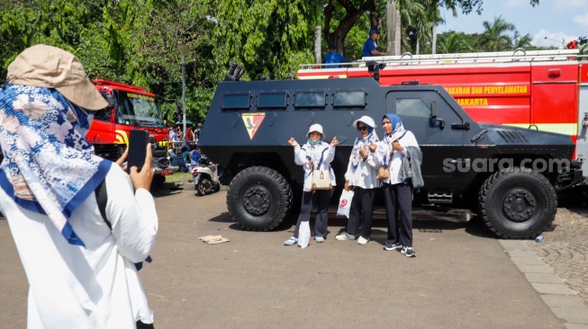 Warga menghadiri HUT ke-79 Bhayangkara di kawasan Monumen Nasional (Monas), Jakarta, Selasa (1/7/2025).  [Suara.com/Alfian Winanto]