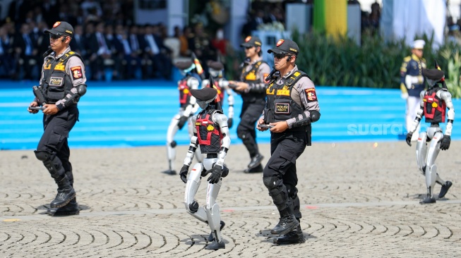 Sejumlah personel robot humanoid mengikuti parade upacara HUT ke-79 Bhayangkara di kawasan Monumen Nasional (Monas), Jakarta, Selasa (1/7/2025).  [Suara.com/Alfian Winanto]