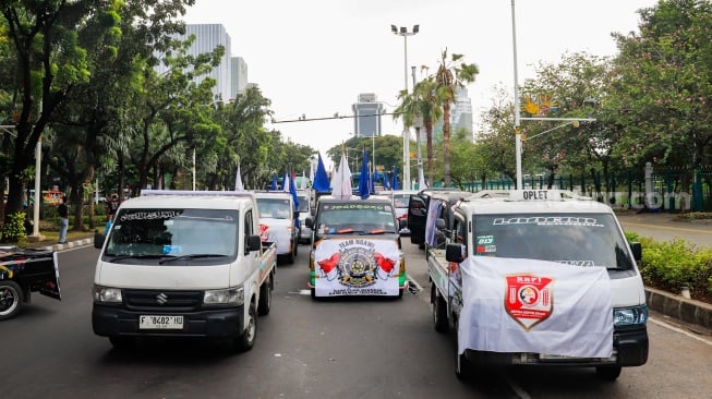 Para sopir truk saat menggelar aksi soal nol kelebihan muatan atau zero over dimensi over loading (ODOL) di Jalan Medan Merdeka Selatan, Jakarta, Rabu (2/7/2025). [Suara.com/Alfian Winanto]
