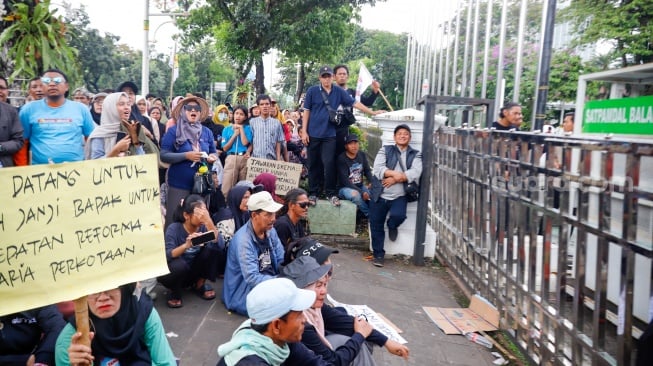Massa dari Jaringan Rakyat Miskin Kota (JRMK) melakukan unjuk rasa di depan Balai Kota Jakarta, Rabu (2/7/2025). [Suara.com/Alfian Winanto]