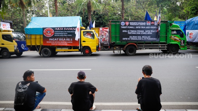Para sopir truk saat menggelar aksi soal nol kelebihan muatan atau zero over dimensi over loading (ODOL) di Jalan Medan Merdeka Selatan, Jakarta, Rabu (2/7/2025). [Suara.com/Alfian Winanto]