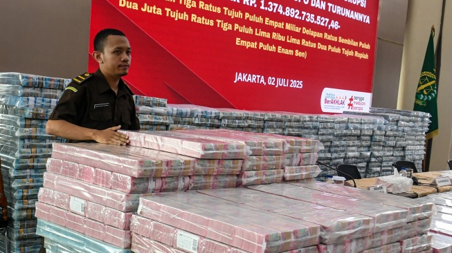 Petugas merapikan barang bukti uang sitaan saat konferensi pers terkait tindak pidana korupsi pemberian fasilitas crude palm oil (CPO) dan turunannya di Gedung Bundar Jampidus Kejaksaaan Agung, Jakarta, Rabu (2/7/2025). [ANTARA FOTO/Muhammad Adimaja/tom]