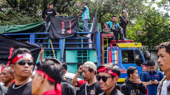 Para sopir truk saat menggelar aksi soal nol kelebihan muatan atau zero over dimensi over loading (ODOL) di Jalan Medan Merdeka Selatan, Jakarta, Rabu (2/7/2025). [Suara.com/Alfian Winanto]