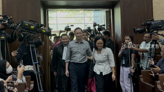 Mantan Menteri Perdagangan, Thomas Trikasih Lembong alias Tom Lembong, merangkul istrinya, Francisca Wiharja jelang sidang tuntutan kasus dugaan korupsi importasi gula. (Suara.com/Dea)