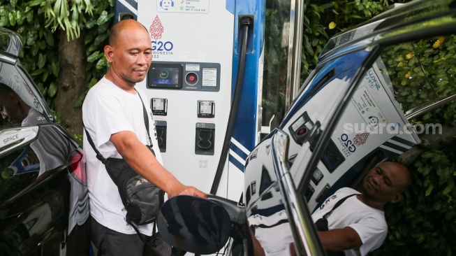 Pemilik kendaraan melakukan pengisian daya kendaraan listrik di SKPLU, Jakarta, Senin (7/7/2025). [Suara.com/Alfian Winanto]