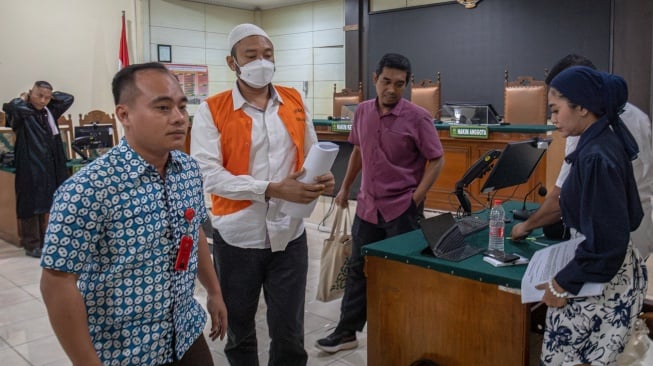 Terdakwa kasus dugaan penembakan yang menewaskan siswa SMKN 4 Semarang berinisial GRO (17) Robig Zaenudin (kedua kiri) berjalan keluar ruang sidang seusai menjalani sidang pembacaan tuntutan di Pengadilan Negeri Semarang, Jawa Tengah, Selasa (8/7/2025). [ANTARA FOTO/Aji Styawan/agr]