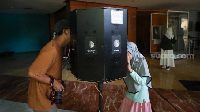 Pengunjung menyaksikan simulasi langit dan penjelasan mengenai astronomi di planetarium mini, kawasan Taman Ismail Marzuki, Jakarta, Selasa (8/7/2025). [Suara.com/Alfian Winanto]