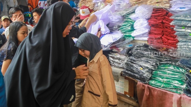 Warga memilih perlangkapan sekolah di Pasar Jatinegara, Jakarta, Kamis (10/7/2025). [Suara.com/Alfian Winanto]
