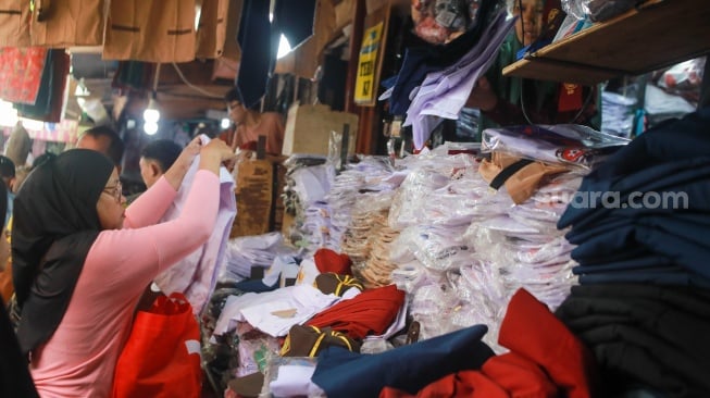 Warga memilih perlangkapan sekolah di Pasar Jatinegara, Jakarta, Kamis (10/7/2025). [Suara.com/Alfian Winanto]