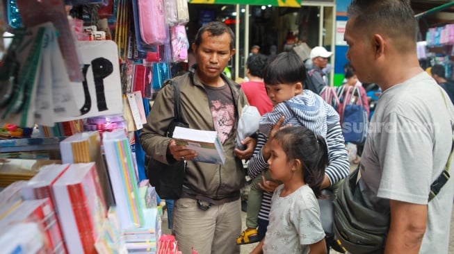 Warga memilih perlangkapan sekolah di Pasar Jatinegara, Jakarta, Kamis (10/7/2025). [Suara.com/Alfian Winanto]