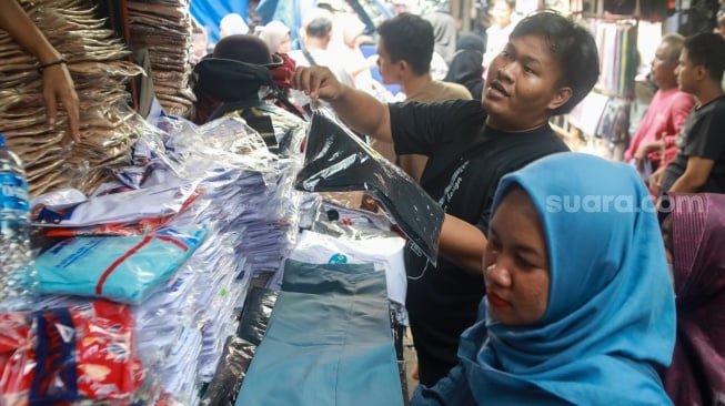 Warga memilih perlangkapan sekolah di Pasar Jatinegara, Jakarta, Kamis (10/7/2025). [Suara.com/Alfian Winanto]