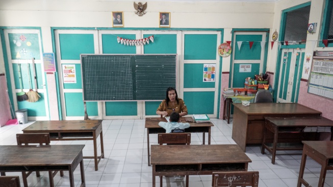 Guru mengajar seorang siswa kelas satu saat kegiatan Masa Pengenalan Lingkungan Sekolah Pendidikan (MPLS) di SD Negeri Kauman 27 Solo, Jawa Tengah, Senin (14/7/2025). [ANTARA FOTO/Mohammad Ayudha/rwa]