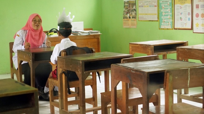 Guru memberikan pengajaran baca tulis kepada satu-satunya murid kelas 1 di SDN 1 Kendalrejo, Trenggalek, Jawa Timur, Senin (14/7/2025). [ANTARA FOTO/Destyan Sujarwoko/rwa]