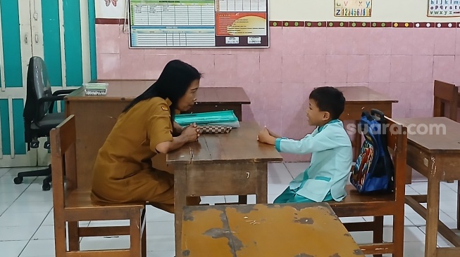 Abrizam Wahyu Irtaza, siswa kelas satu SDN Kauman 27 Kota Solo saat masuk hari pertama sekolah, Senin (14/7/2025). [Suara.com/Ari Welianto]