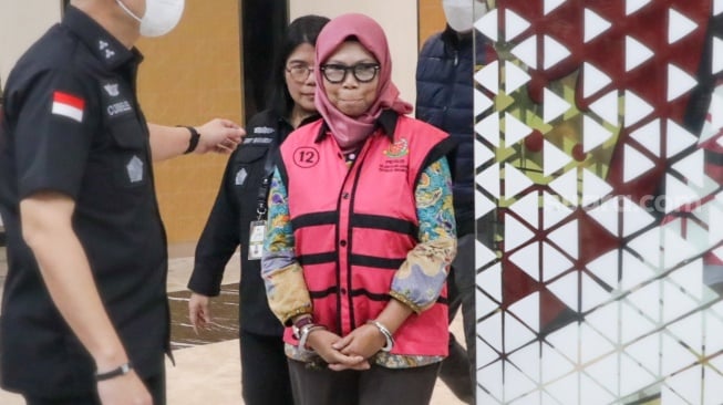 Tersangka Direktur Sekolah Dasar Direktorat Jenderal Pendidikan Anak Usia Dini, Pendidikan Dasar dan Pendidikan Menengah tahun 2020-2021, Sri Wahyuningsih dibawa ke mobil tahanan di Kejaksaan Agung, Jakarta, Selasa (15/7/2025). [Suara.com/Alfian Winanto]