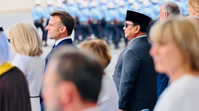 Presiden Prabowo Subianto (kanan) berjabat tangan dengan Presiden Prancis Emmanuel Macron (kedua kiri) disaksikan istri Brigitte Macron (kiri) saat meghadiri parade Bastille Day di jalan Champs-Elysees, Paris, Prancis, Senin (14/7/2025). [HO/Setpres-Laily Rachev]
