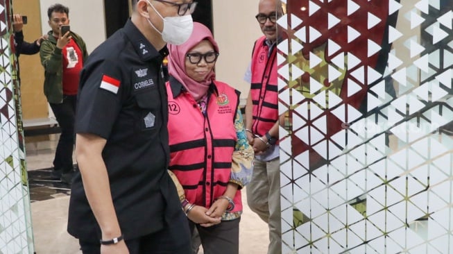 Tersangka Direktur Sekolah Dasar Direktorat Jenderal Pendidikan Anak Usia Dini, Pendidikan Dasar dan Pendidikan Menengah tahun 2020-2021, Sri Wahyuningsih dibawa ke mobil tahanan di Kejaksaan Agung, Jakarta, Selasa (15/7/2025). [Suara.com/Alfian Winanto]