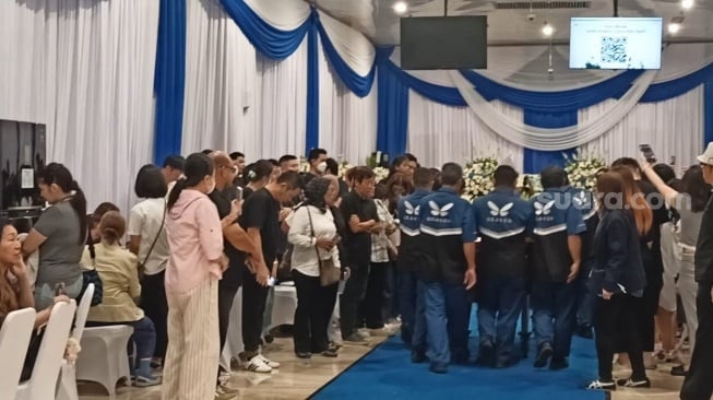 Giorgio Antonio dari kejauhan tampak menggendong anak Sarwendah saat melayat Hendrik Lo di di rumah duka Grand Heaven, Jakarta Utara pada Sabtu,19 Juli 2025 [Suara.com/Rena Pangesti]