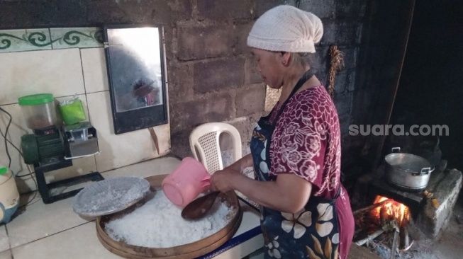 Dariyah menanak nasi jagung di dapurnya yang sederhana di Desa Jati, Kecamatan Sawangan, Magelang. (Suara.com/ Angga Haksoro A). 