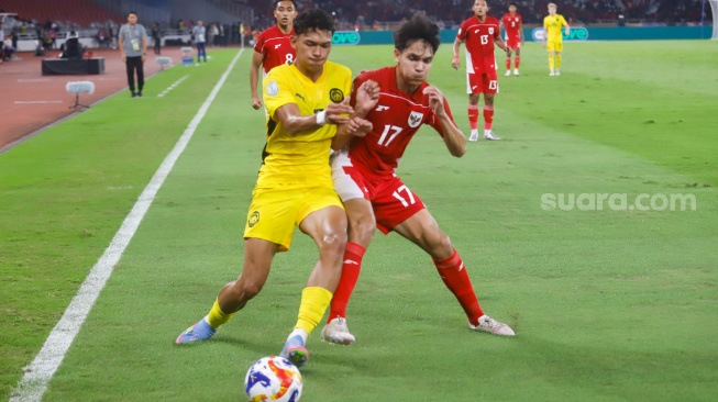Pesepak bola Timnas Indonesia U-23 Victor Benjamin berebut bola dengan pemain Malaysia U-23 dalam pertandingan penyisihan Grup A Piala AFF U-23 2025 di Stadion Utama Gelora Bung Karno (SUGBK), Senayan, Jakarta, Senin (21/7/2025). [Suara.com/Alfian Winanto]