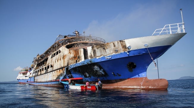 Sejumlah kru dari PT Surya Pasific Indonesia (SPI) menggunakan perahu melakukan upaya pendinginan KM Barcelona setelah terbakar di perairan Talise, Minahasa Utara, Sulawesi Utara, Selasa (22/7/2025). [ANTARAFOTO/Yegar Sahaduta Mangiri/YU/tom]