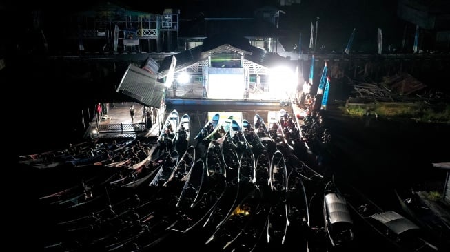 Foto udara sejumlah warga menonton bioskop terapung dari perahunya di Desa Muara Enggelam, Muara Wis, Kutai Kartanegara, Kalimantan Timur, Selasa (22/7/2025). [ANTARA FOTO/M Risyal Hidayat/tom] 
