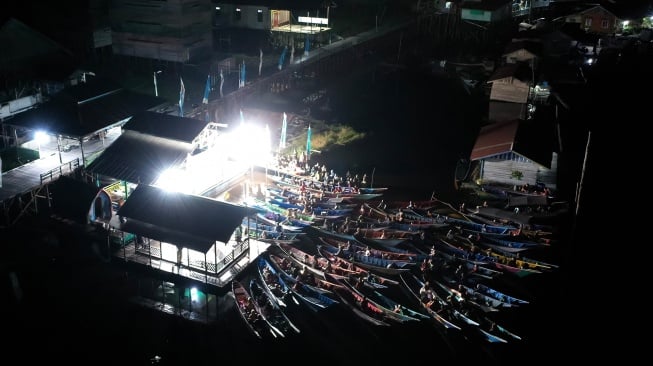 Foto udara sejumlah warga menonton bioskop terapung dari perahunya di Desa Muara Enggelam, Muara Wis, Kutai Kartanegara, Kalimantan Timur, Selasa (22/7/2025). [ANTARA FOTO/M Risyal Hidayat/tom] 